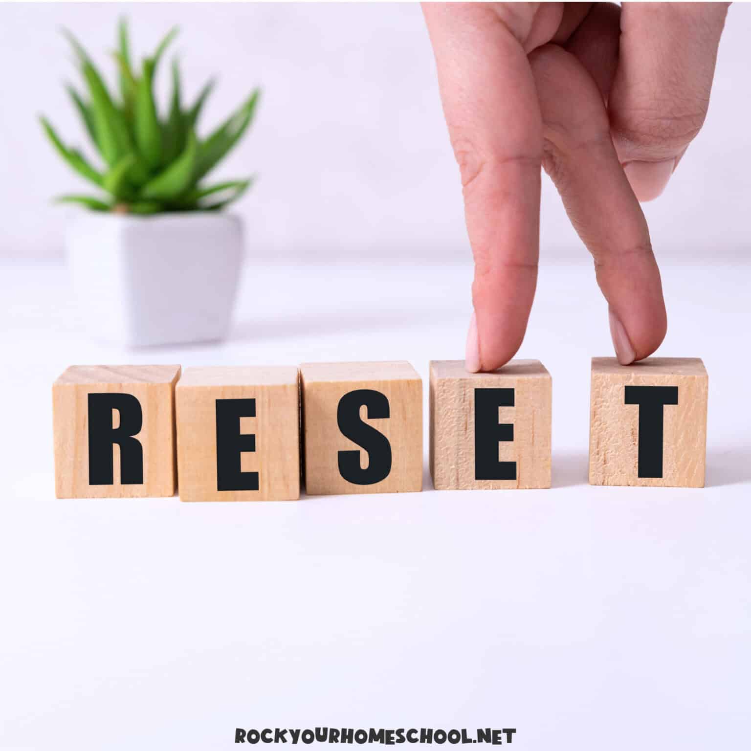 The word reset in wood black letters with fingers to feature how to reset your homeschool day.