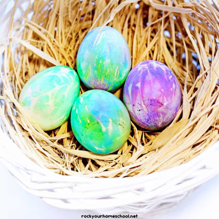 Examples of tie-dye Easter eggs in basket with straw.