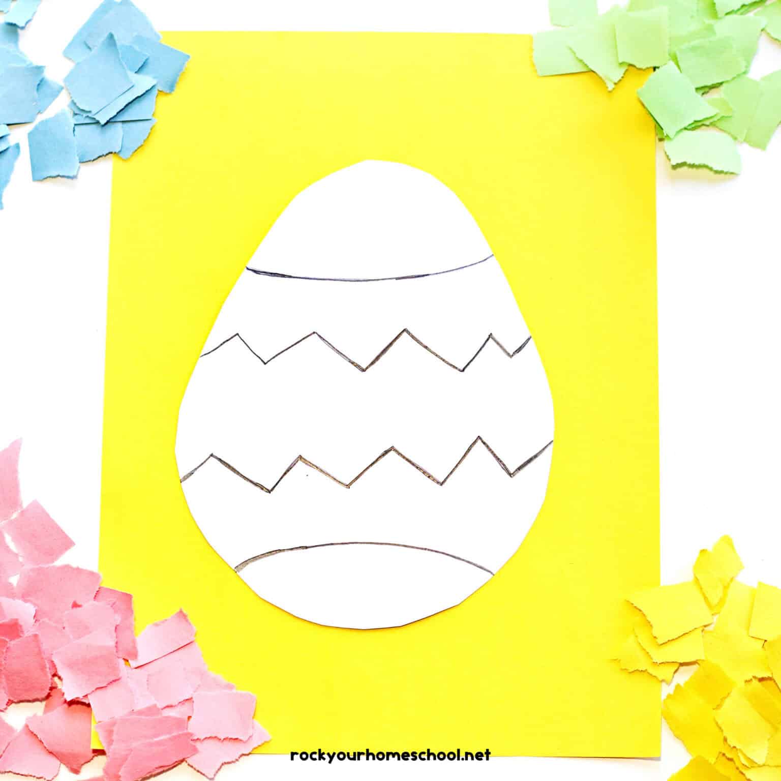 Easter egg with black lines on yellow paper with light blue, green, pink and yellow torn paper squares.