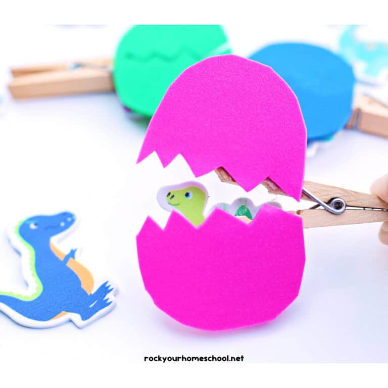 Example of fun dinosaur egg craft on clothespin with pink foam sheet with dinosaur stickers.