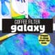 Blue spray bottle, coffee filters and washable markers with examples of coffee filter galaxy craft on black construction paper.