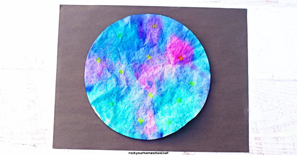 Example of coffee filter galaxy craft with blue, purple, pink, and neon yellow on black construction paper.
