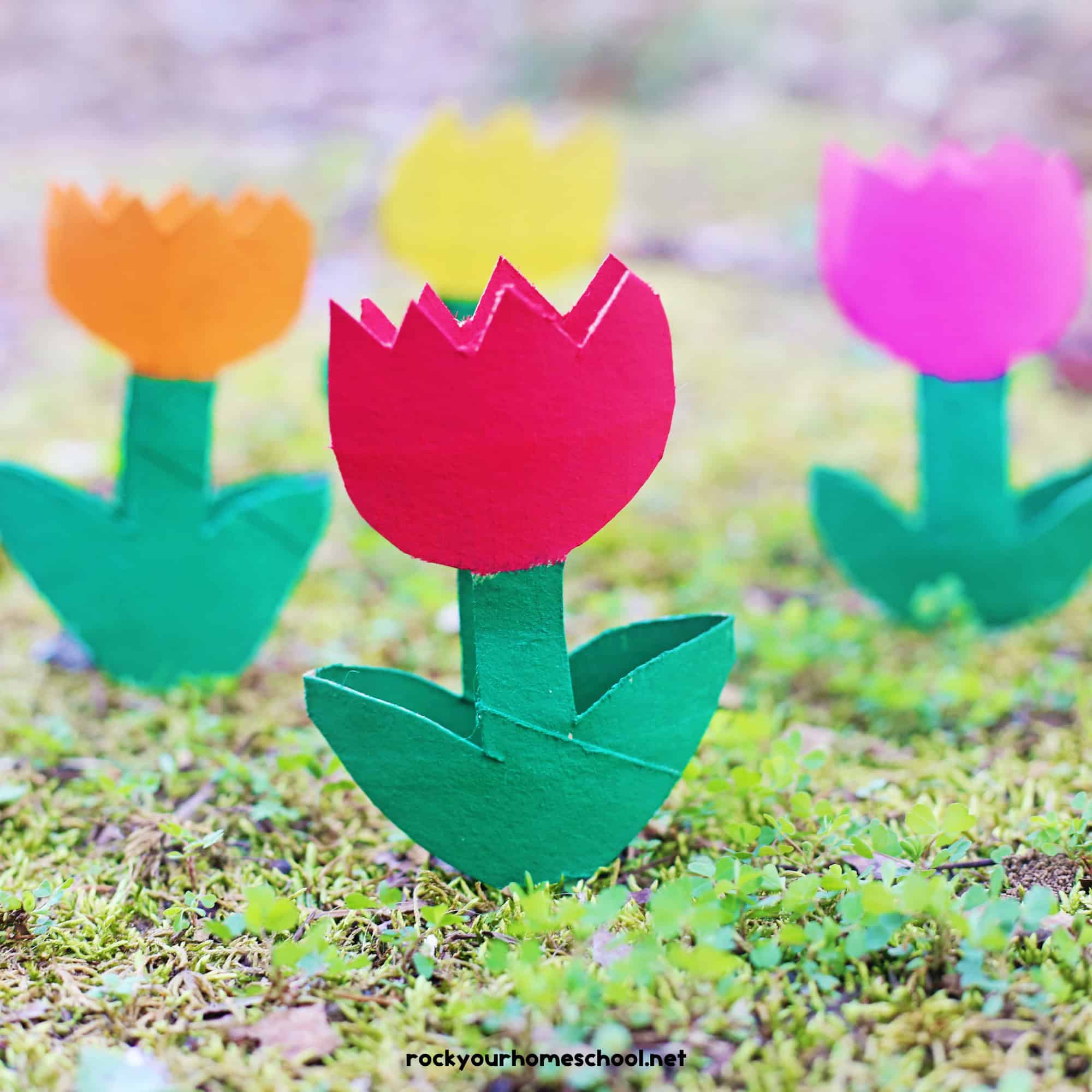 Four examples of toilet paper roll tulips in orange, red, yellow, and pink.