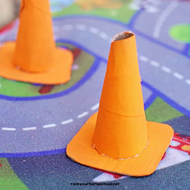 Two examples of orange traffic cone craft made with toilet paper rolls.