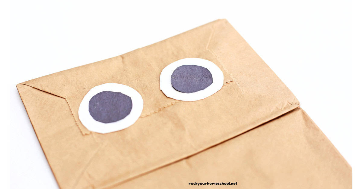 Black and white circles for paper eyes on brown paper bag.