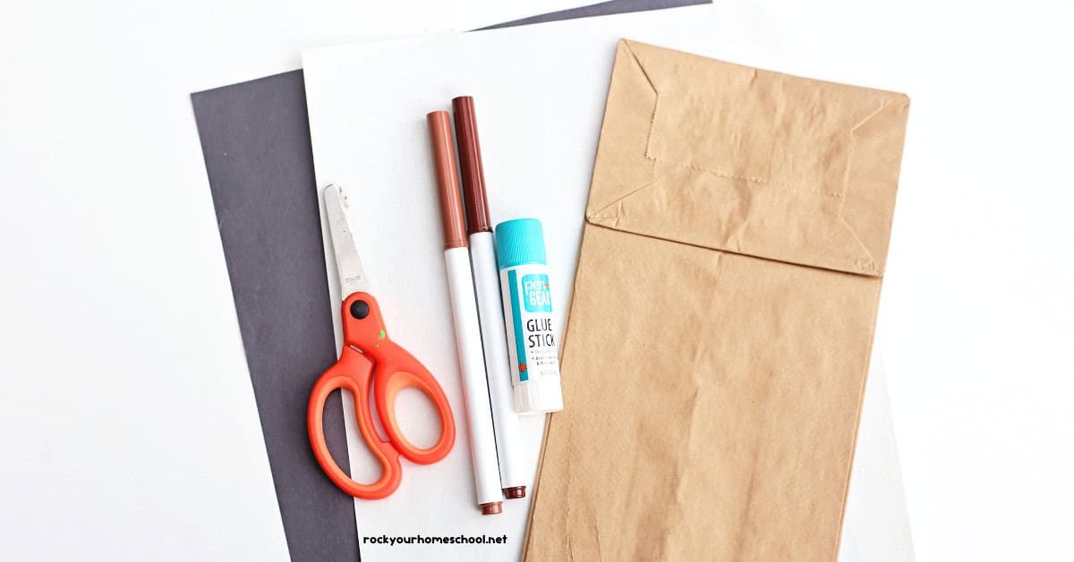 Paper bag, glue stick, brown markers, scissors, and black and white construction paper.