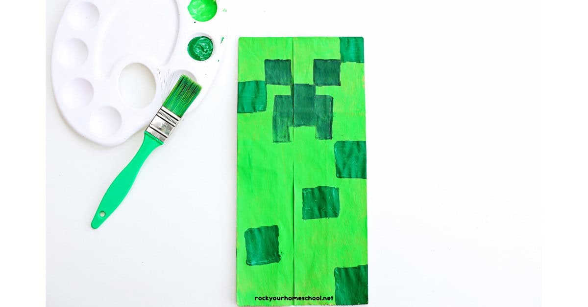 Example of green Creeper paper bag craft with green paint brush and paints.