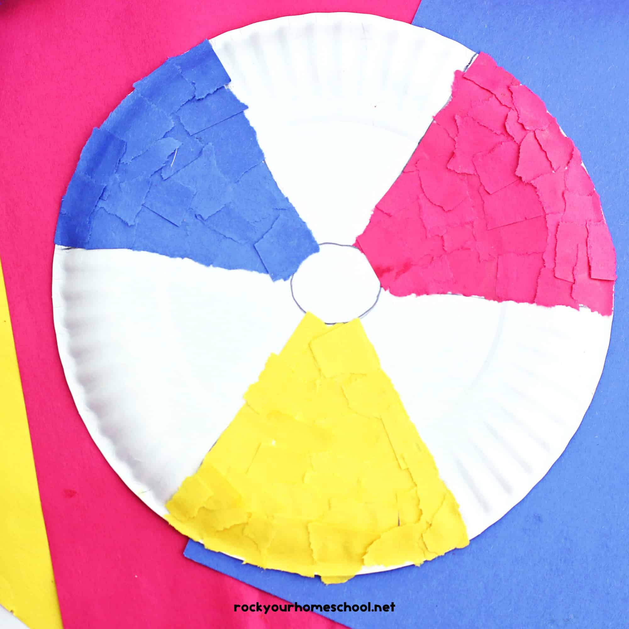 Example of paper plate beach ball craft made with red, yellow, and blue torn construction paper.