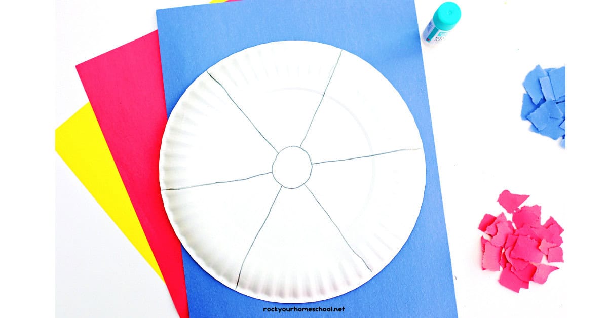 Paper plate with pencil drawing of beach ball with glue stick, yellow, red, and blue torn paper squares.