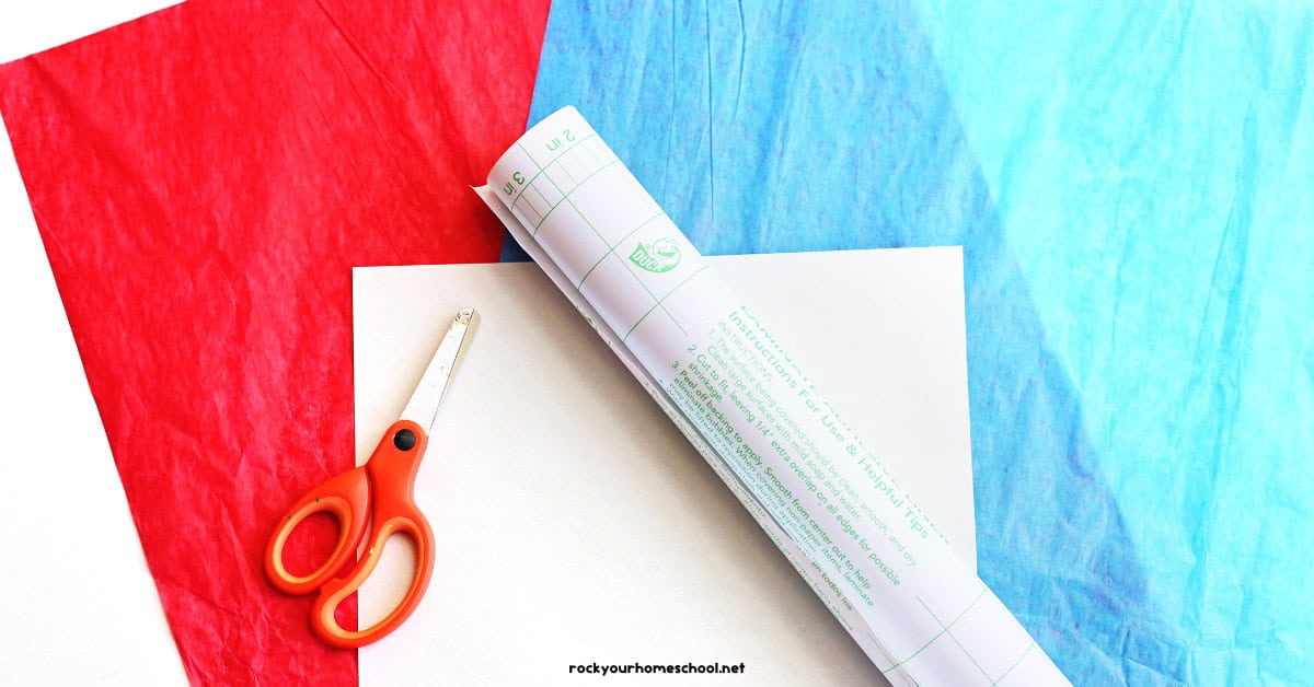 Red and blue tissue paper, white cardstock, scissors, and clear contact paper.