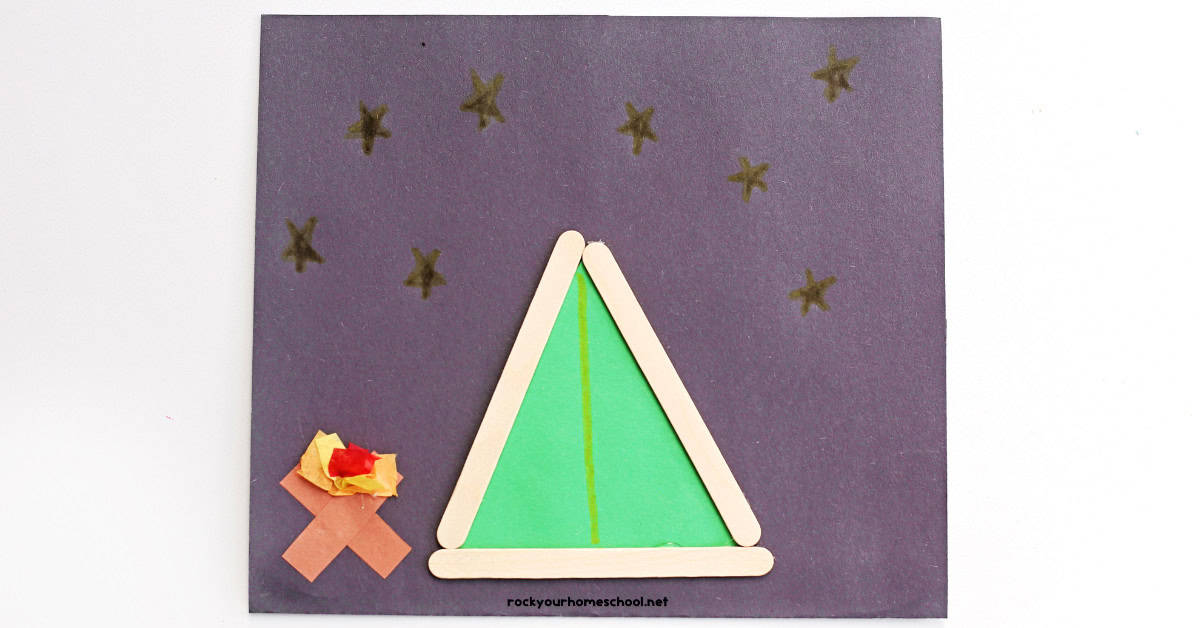 Example of popsicle stick tent craft with green paper on black construction paper and paper campfire.