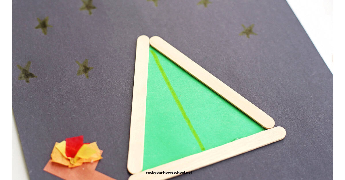 Example of popsicle stick tent craft on black construction paper. 