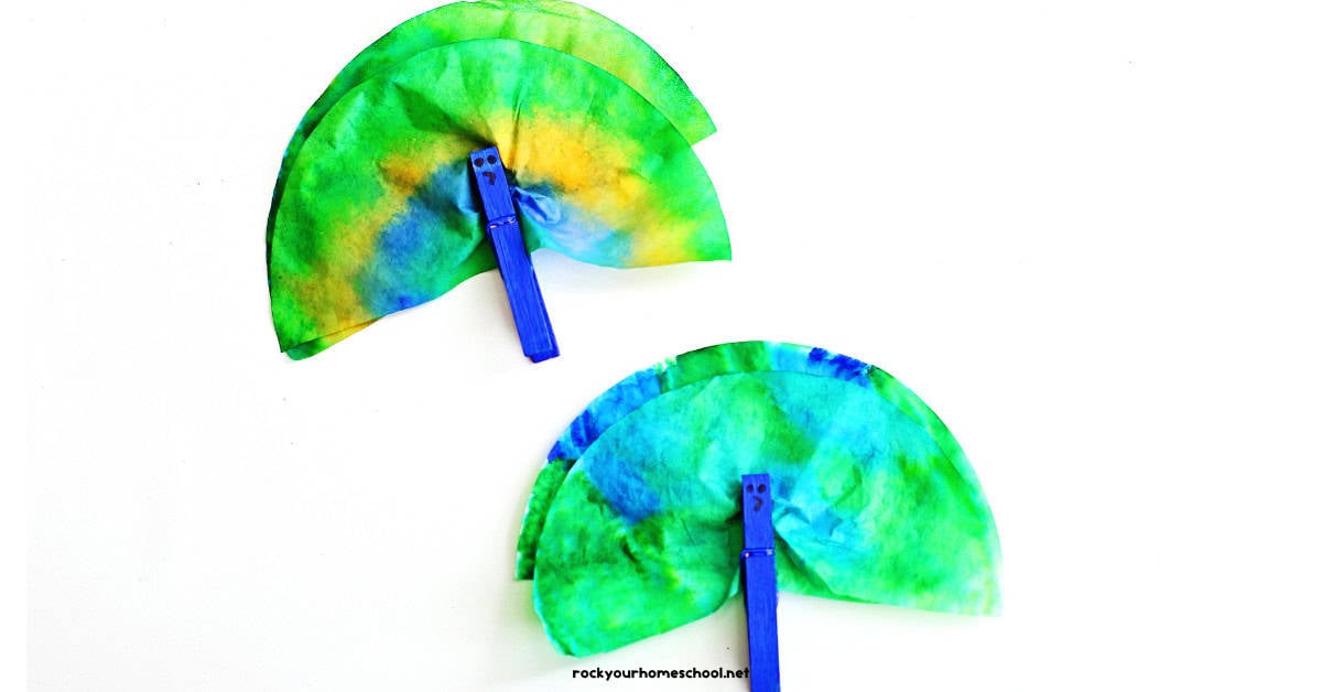 Two examples of coffee filter peacocks with blue clothespins.