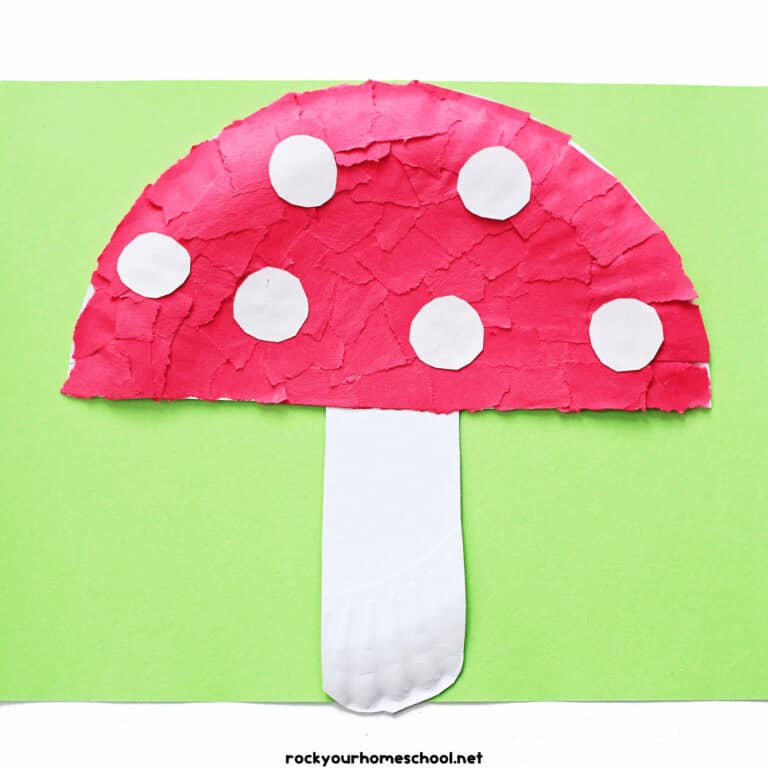 Example of paper plate mushroom craft made with red torn paper pieces and white paper circles.