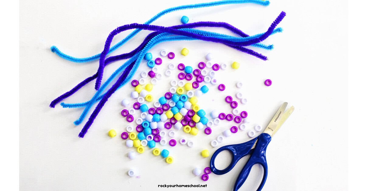 Blue and purple pipe cleaners with pony beads and scissors.