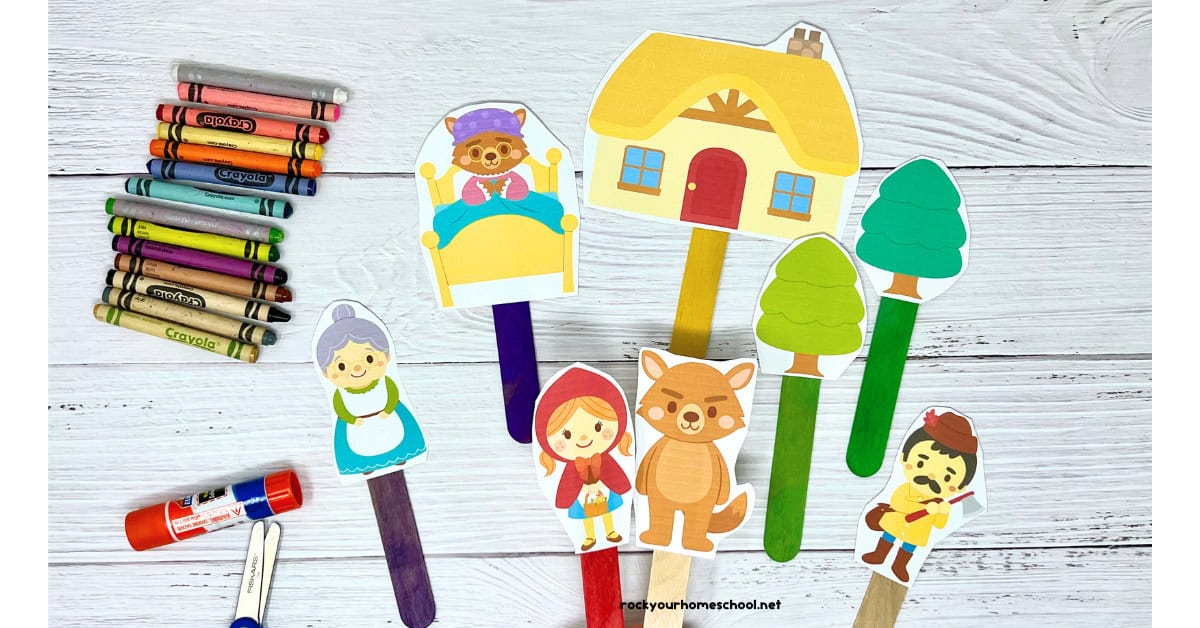 Little Red Riding Hood story props on colorful wood craft sticks with glue stick, scissors, and rainbow of crayons.