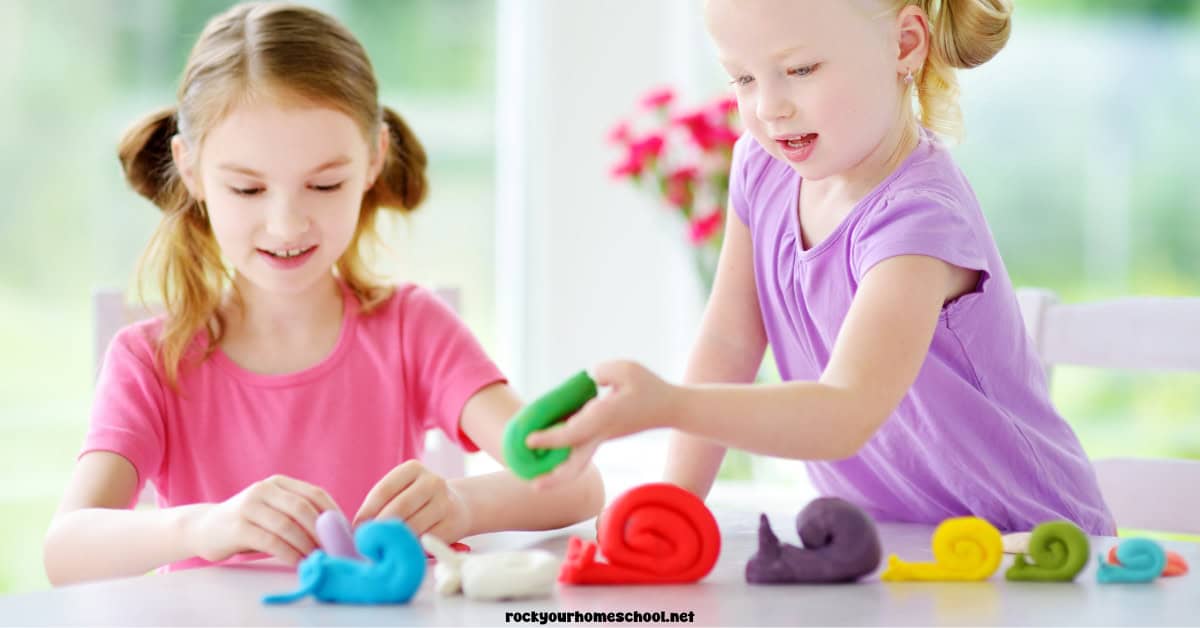 Two girls making playdough snails.