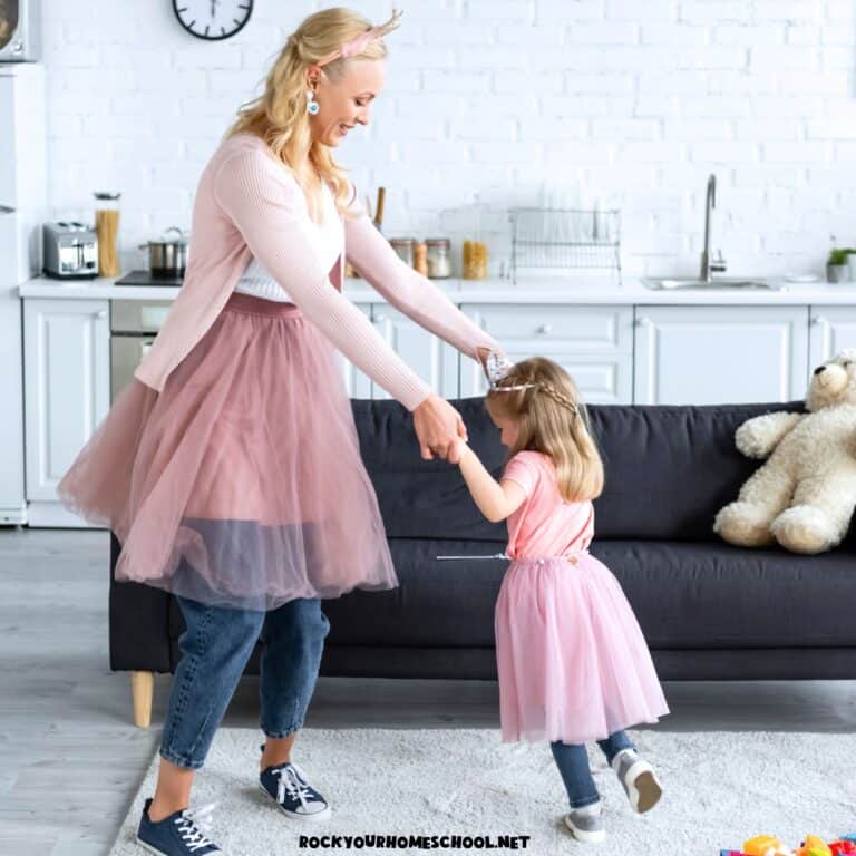 Mom and preschool daughter wearing pink tutus and dancing in living room to feature these music and movement activities for preschoolers.