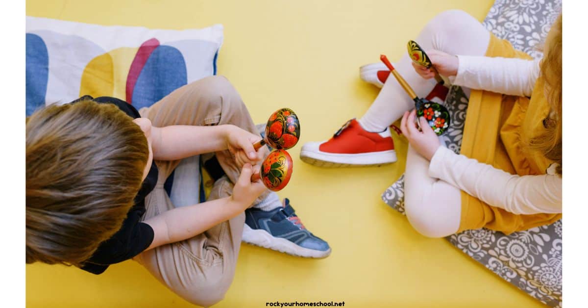 Preschool boy and girl holding wood musical instruments.