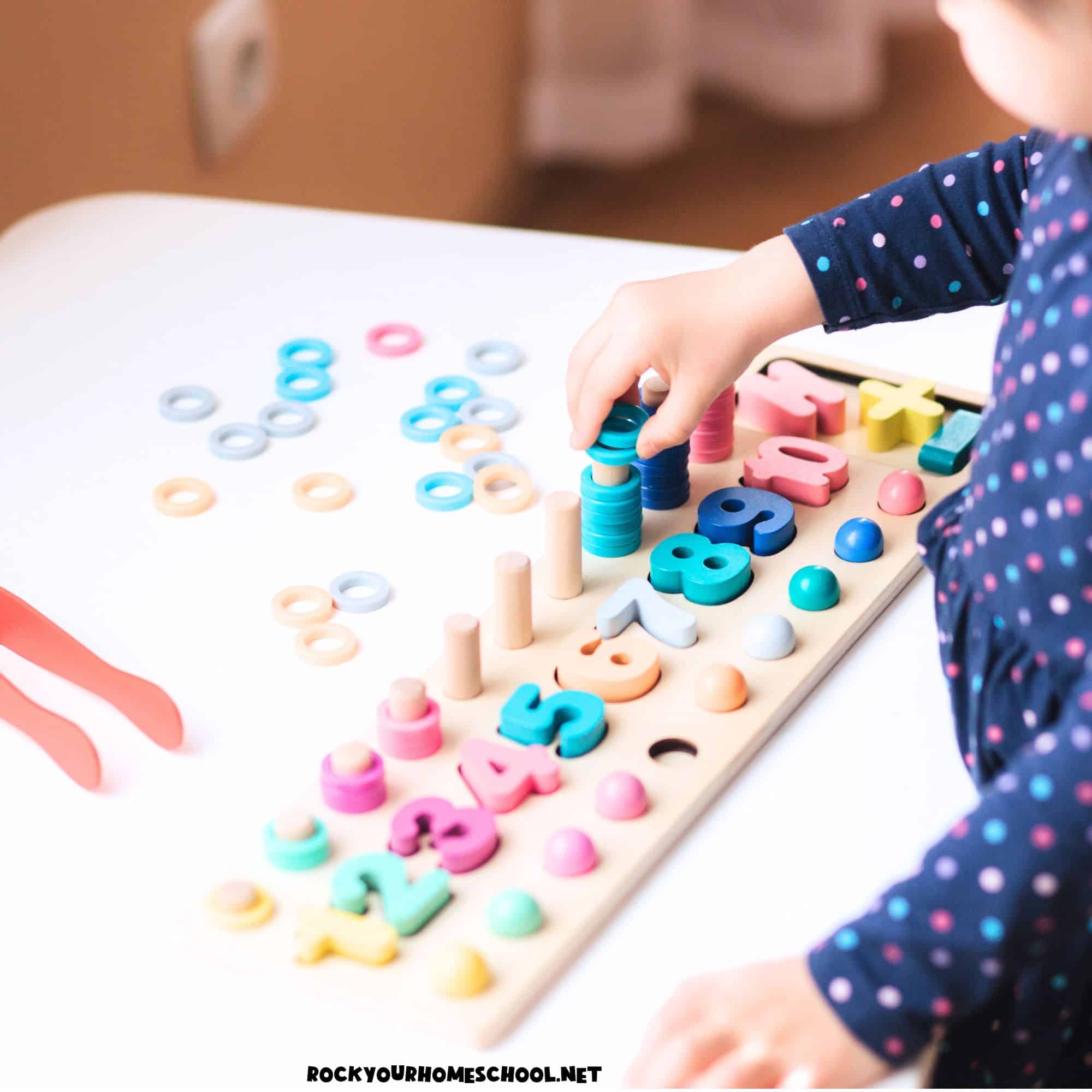 Preschool girl using wood puzzle for number preschool activities.