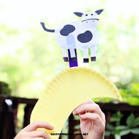 Child playing with Hey Diddle Diddle craft made with paper plate for a fun nursery rhyme activity.