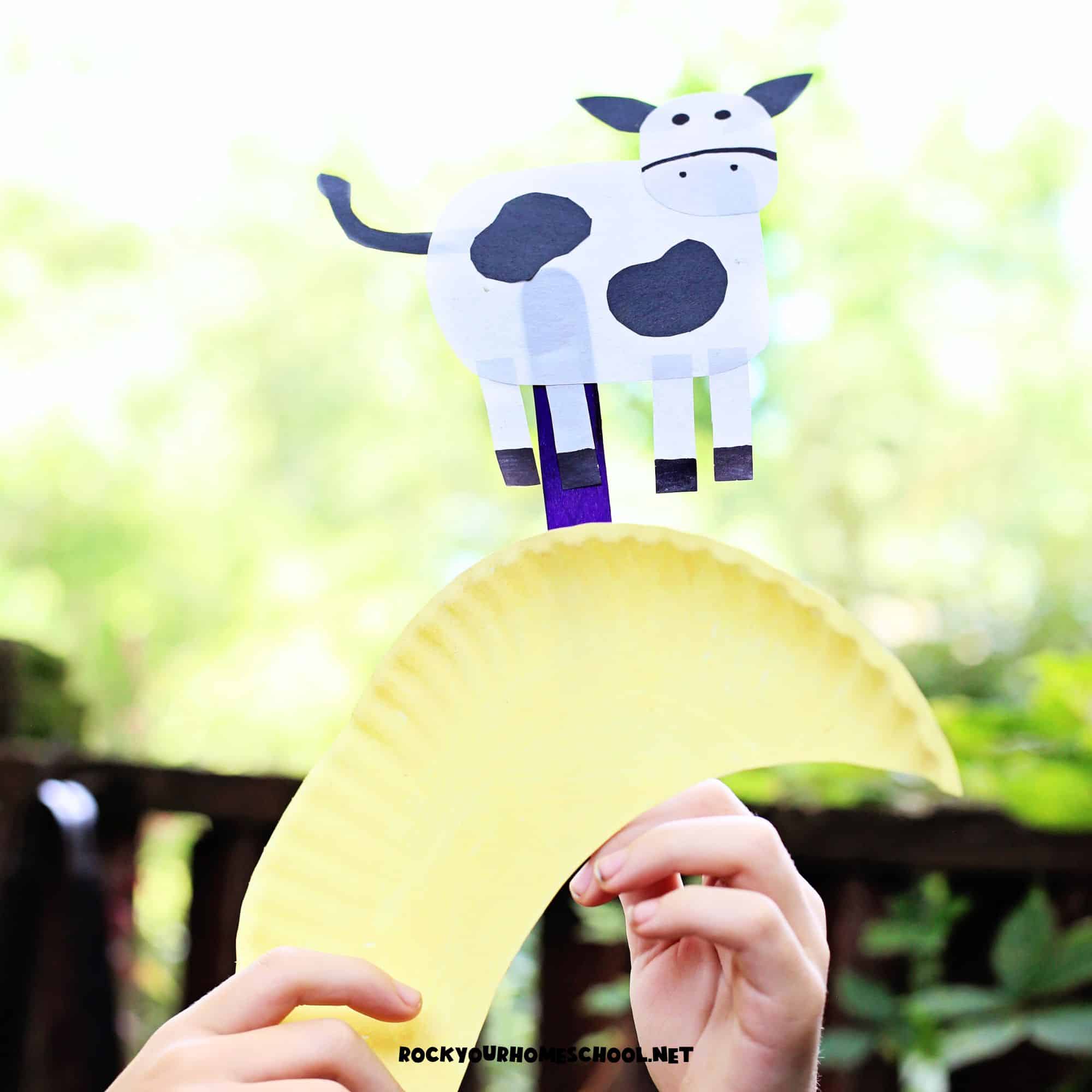 Child playing with Hey Diddle Diddle craft made with paper plate for a fun nursery rhyme activity.