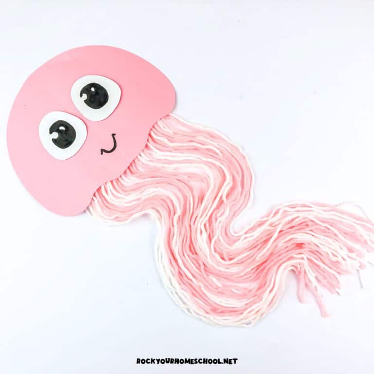 Example of pink and white easy jellyfish craft for kids using paper and yarn.