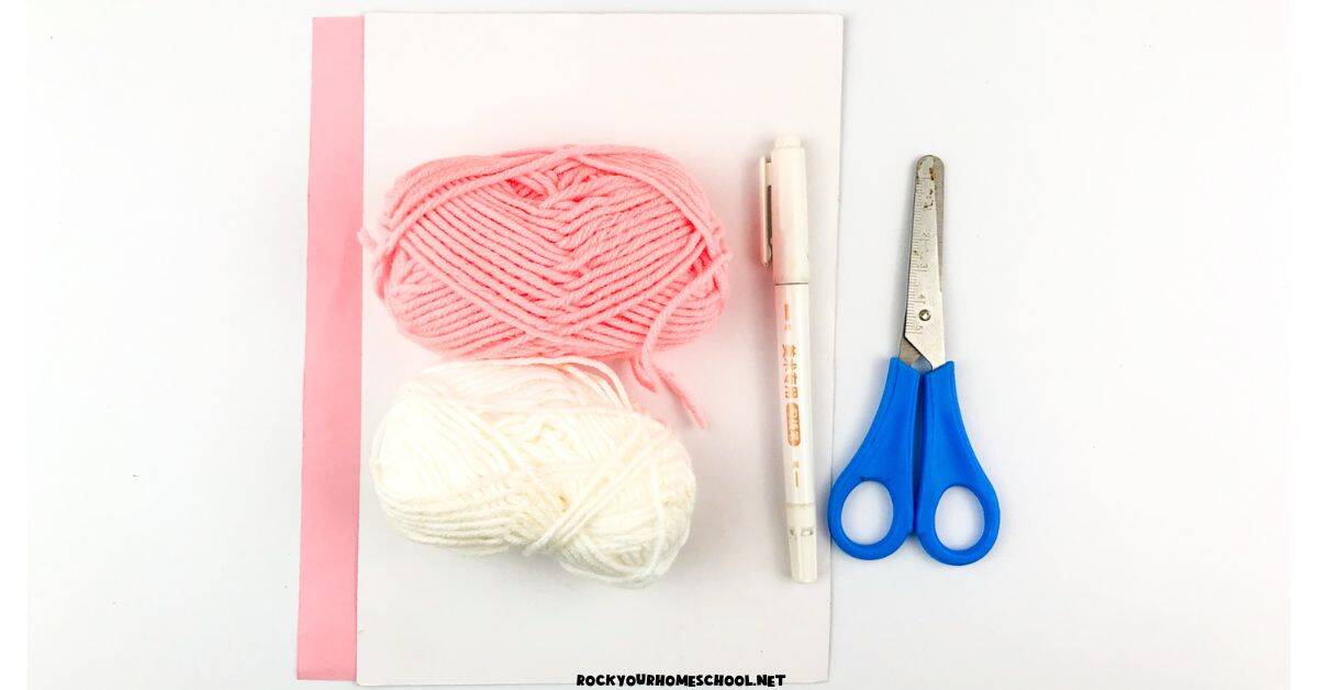 Pink and white paper, pink and white yarn, marker, and scissors.