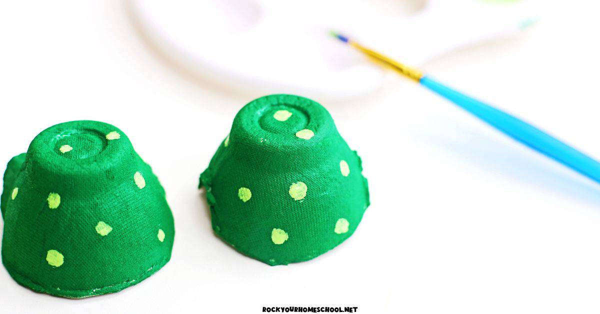 Two egg carton cups painted green with light green dots.