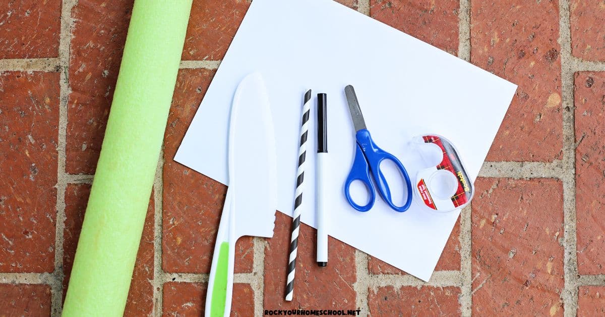 Green pool noodle, white paper, craft knife, paper straw, marker, scissors, and tape.
