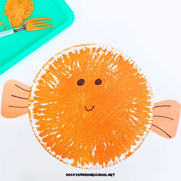 Example of orange fork-painted puffer fish paper plate craft for kids.