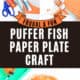 Orange construction paper, black marker, scissors, glue stick, orange paint, fork, and paper plate with examples of fork-painted puffer fish paper plate craft.