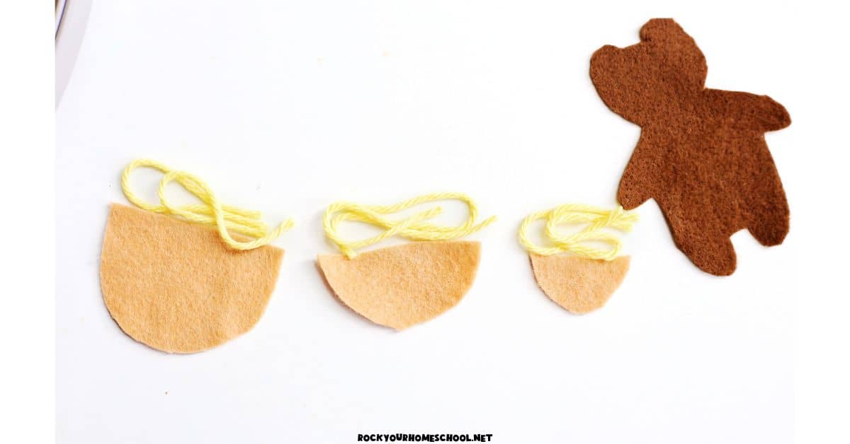 Felt pieces for three bowls and yellow yarn with brown felt bear.