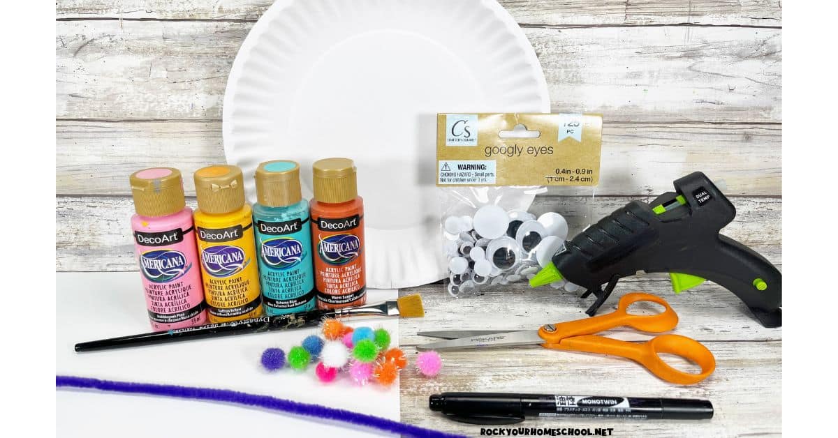 Paper plates, googly eyes, glue gun, scissors, black marker, purple pipe cleaner, pom poms, paint brush, white cardstock, and paints.