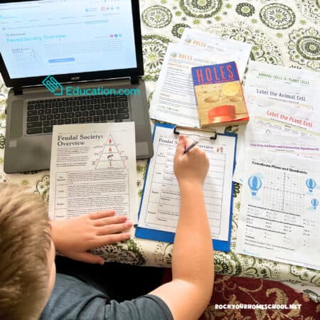 Middle school boy working on 6th grade worksheets from Education.com for social studies, reading, math, and science.