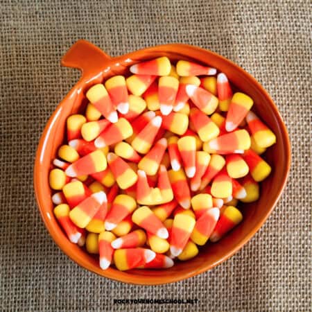 Pumpkin bowl of candy corn on burlap to feature these candy corn activities for kids.