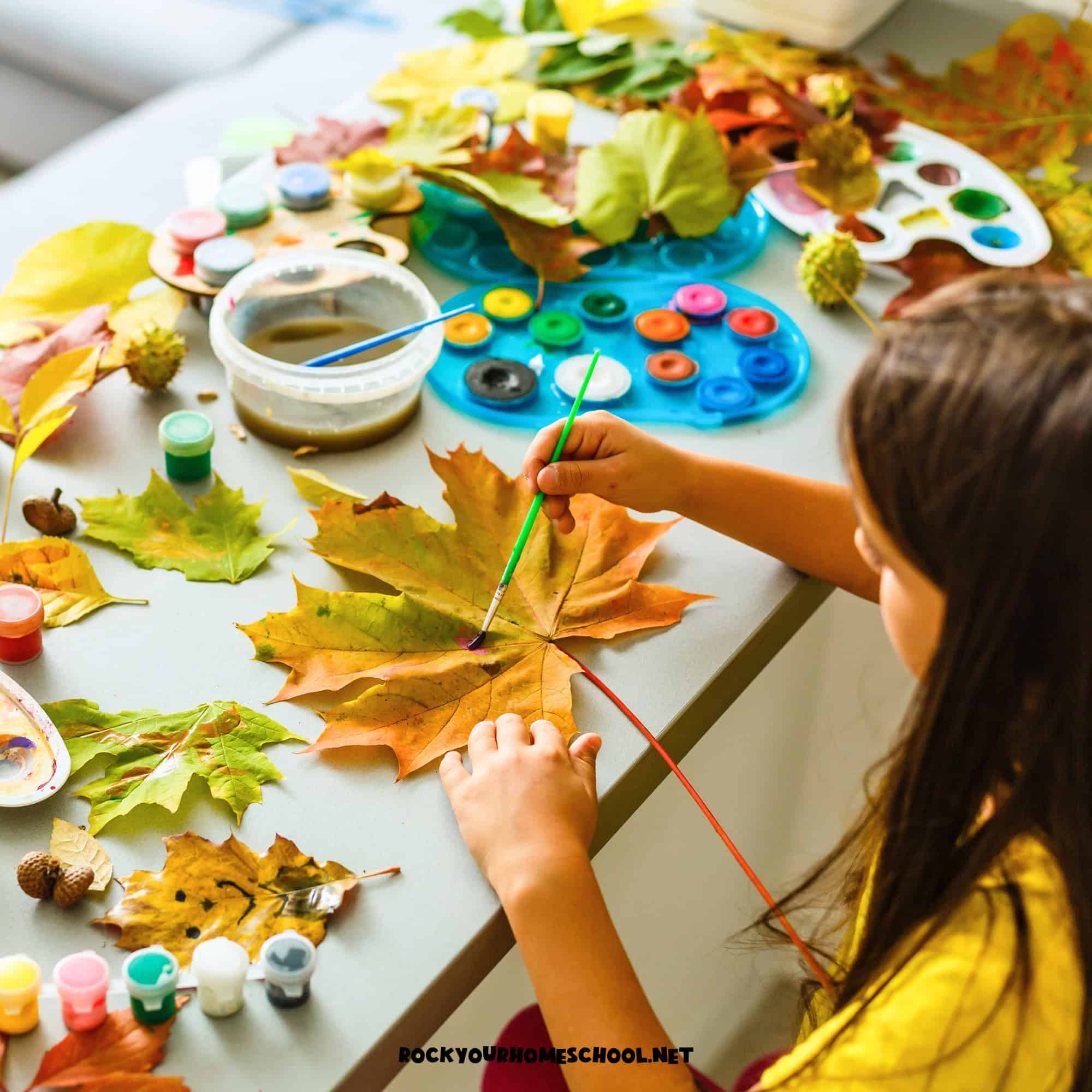 Young girl painting a large leaf as an example of fall indoor activities for kids.