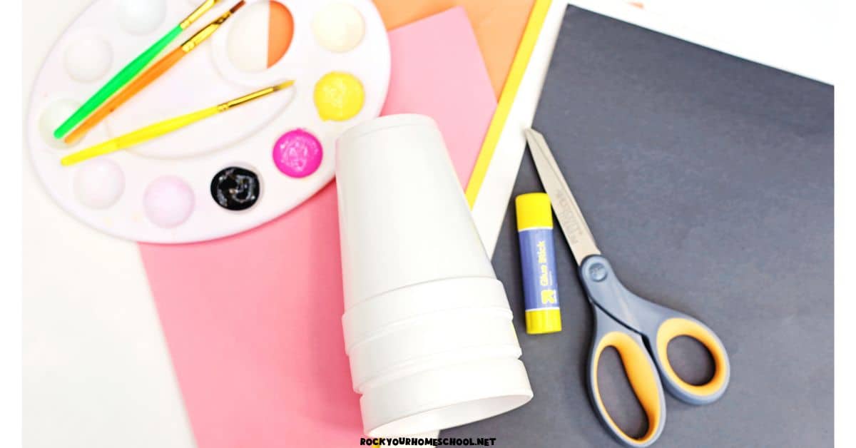 Paint, paint brushes, paper cups, glue stick, scissors, and construction paper.