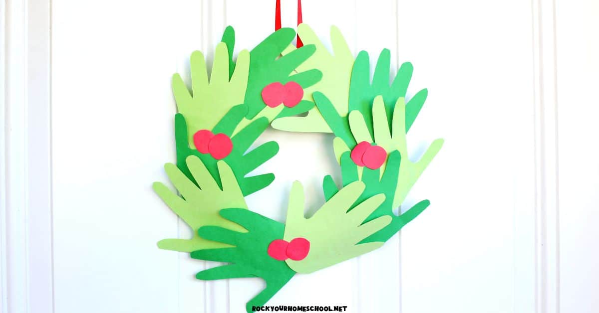 Example of cute and easy Christmas handprint wreath craft for kids hanging on white door. 