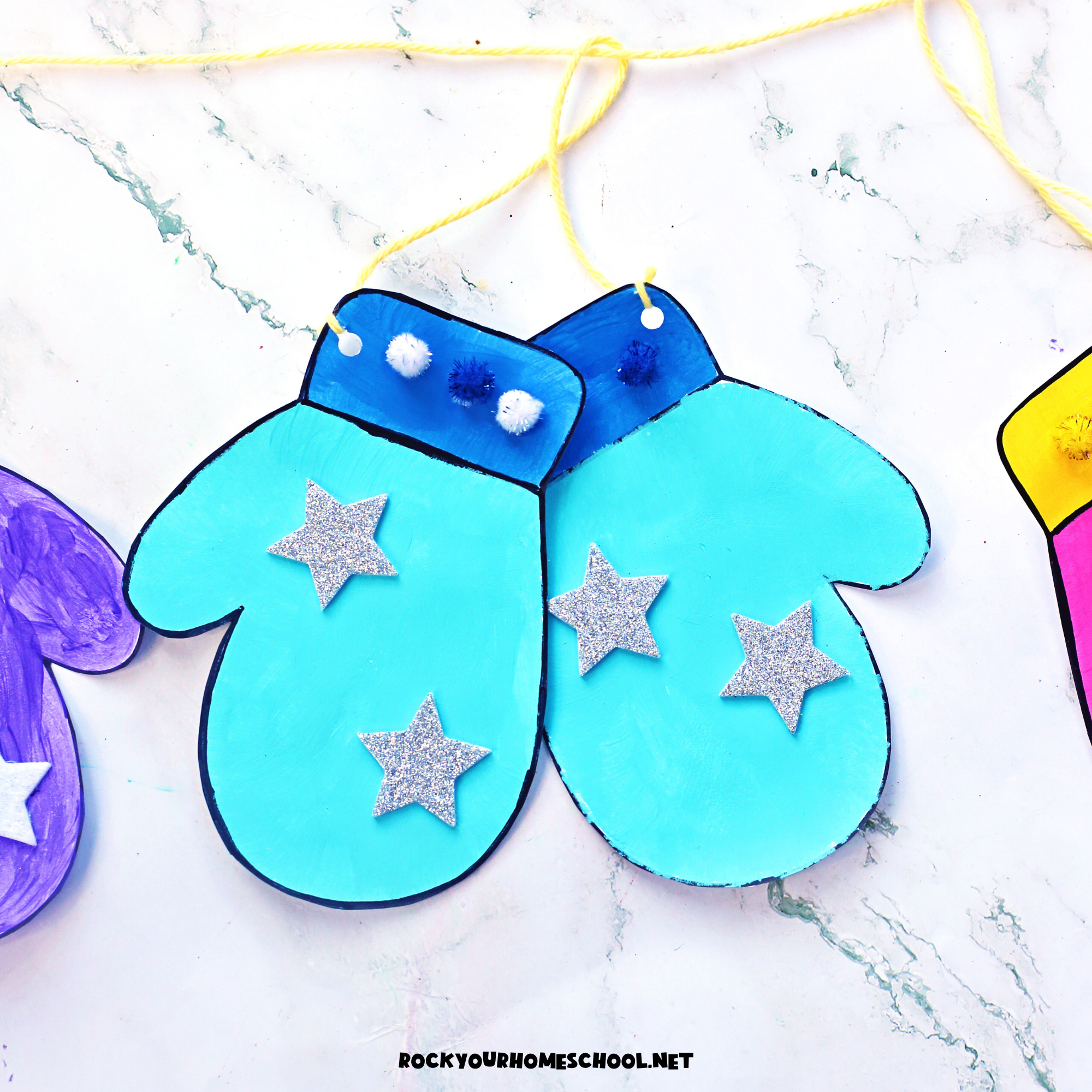 Pair of blue paper mittens craft with star foam stickers to feature this easy winter activity with free printable template.