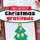 Woman holding free printable pages of Christmas tree gratitude activity with example of Christmas lights on silver ribbon.
