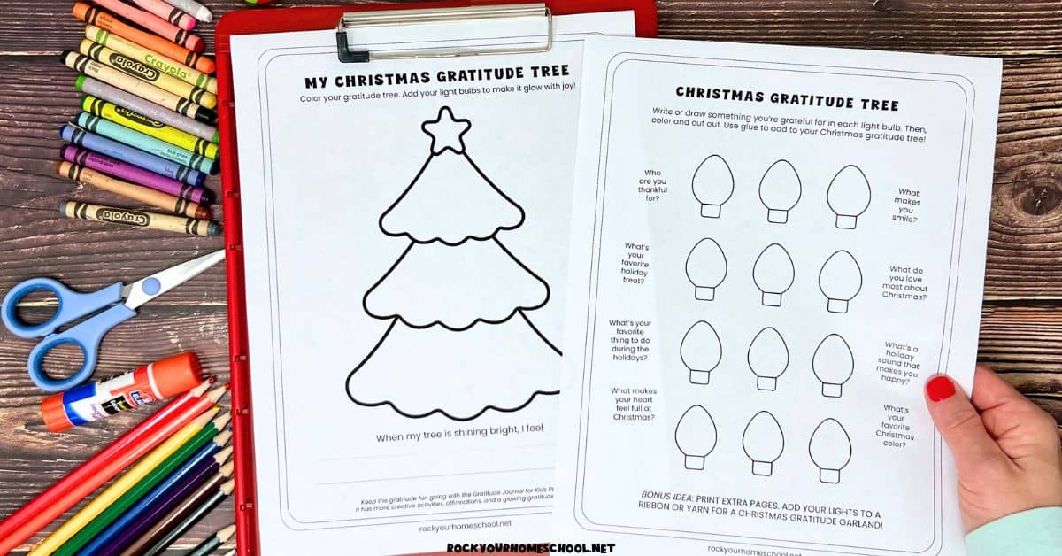 Woman holding pages of free printable Christmas gratitude activity with tree and lights.