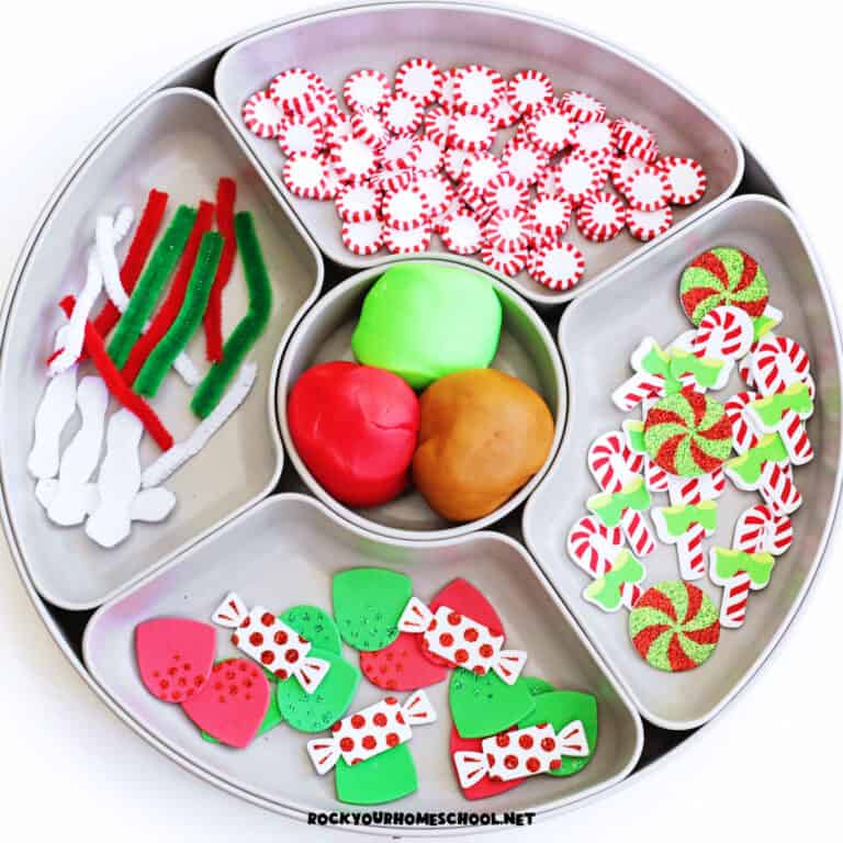 Activity tray with red, green, and brown playdough, pipe cleaners, holiday foam pieces and stickers, peppermint embellishments to feature this gingerbread playdough activity.