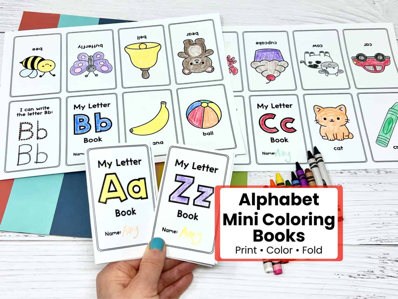Woman holding letter Aa and Aa mini coloring books with examples in background.