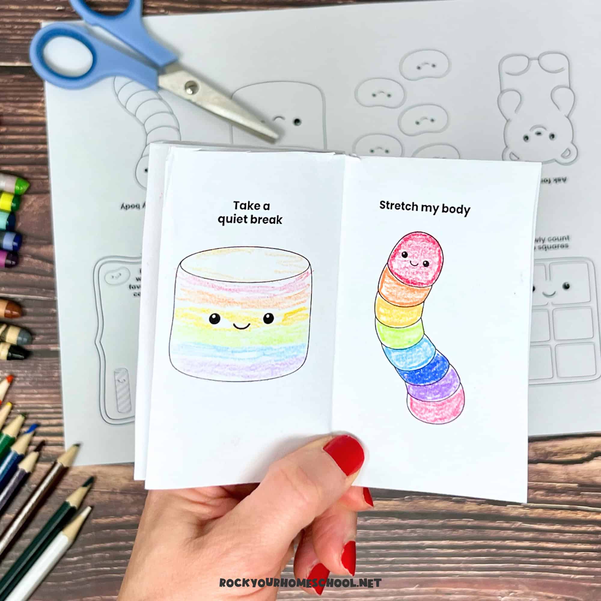 Woman holding free printable coping skills activity that is a mini coloring book featuring cute candy themes.