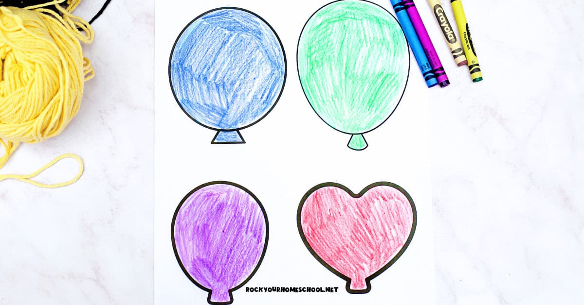 Paper balloon templates colored in with crayons with yellow yarn.