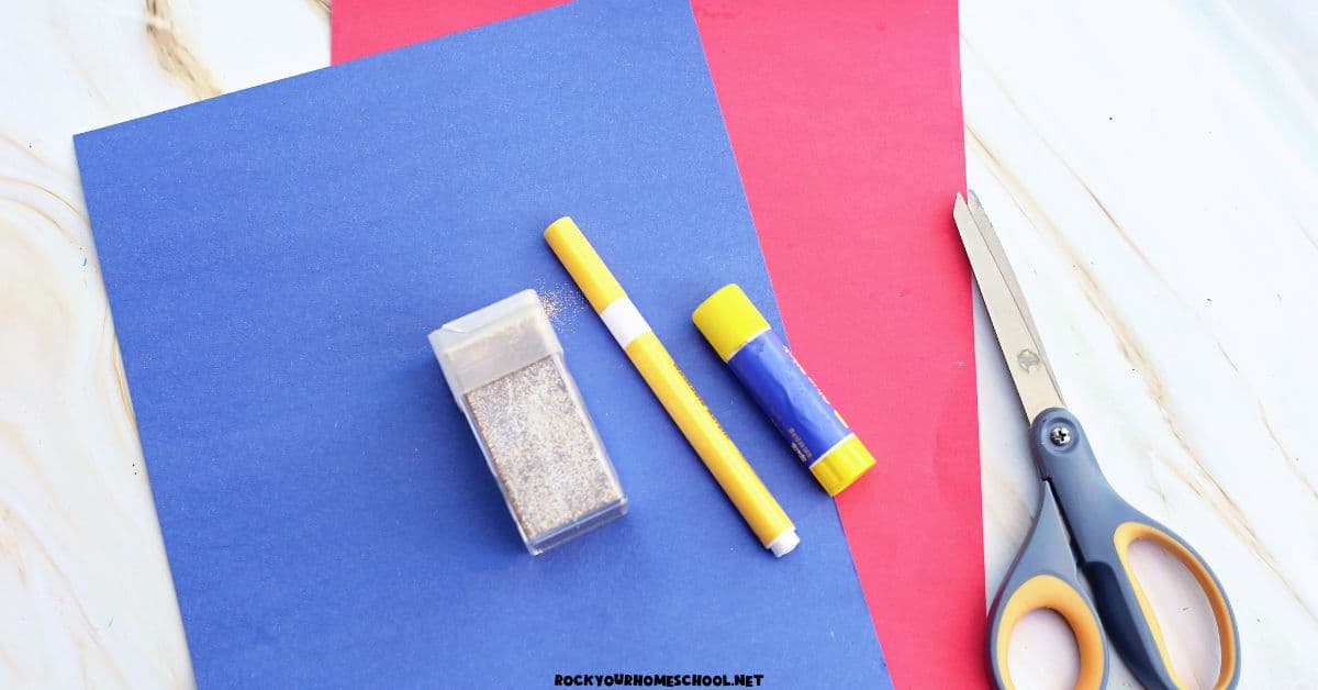 Red and blue construction paper with gold glitter, yellow marker, glue stick, and scissors.