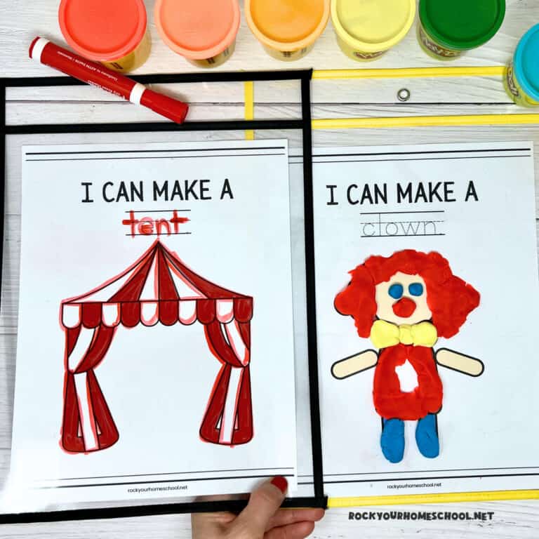 Woman holding examples of free printable circus playdough mats of big top tent and clown.