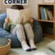 Young boy sitting on blue beanbag chair in corner of room with a basket of books and stuffed animal and a book shelf to show how to make a calm down corner for kids.