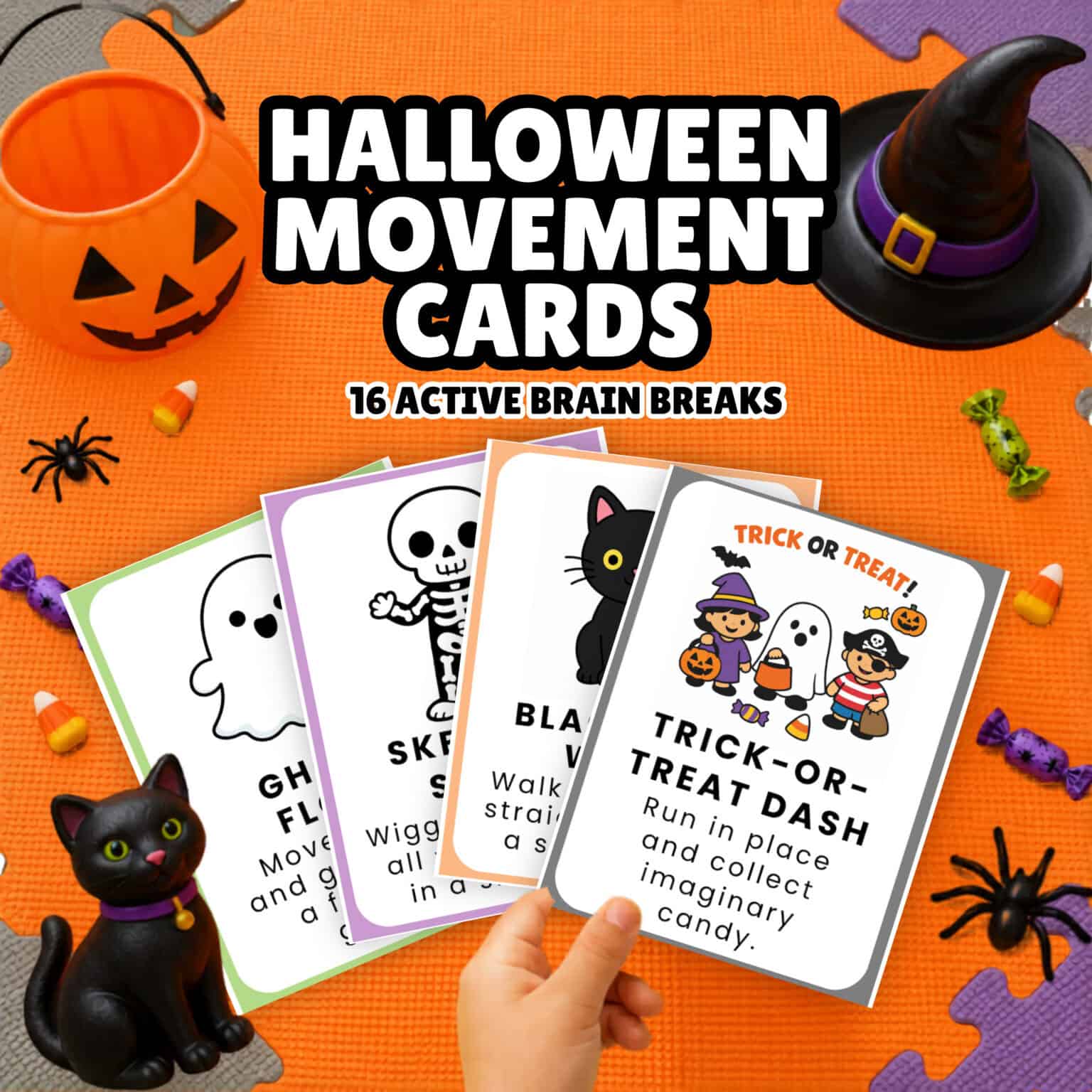 A child's hand holding Halloween movement cards.
